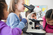 © JGI/Jamie Grill/Blend Images - Students using microscope in classroom