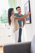 © JGI/Tom Grill/Blend Images - Couple hanging picture together