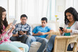 © JGI/Jamie Grill/Blend Images - Hispanic family using cell phones and digital tablets in living room