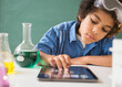 © JGI/Jamie Grill/Blend Images - Mixed race boy using digital tablet in classroom science lab