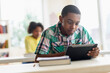 © JGI/Tom Grill/Blend Images - Black student using digital tablet in classroom
