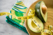 © JGI/Jamie Grill/Blend Images - Close up of halved avocado, measuring tape and napkin on plate