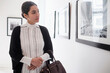 © JGI/Tom Grill/Blend Images - Hispanic woman admiring art in gallery