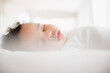 © JGI/Jamie Grill/Blend Images - Mixed Race baby boy sleeping on bed