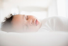 Mixed Race Baby Boy Sleeping On Bed