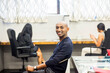 © Adam Hester/Blend Images - Portrait of smiling African American man sitting in office