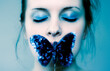 © Aliyev Alexei Sergeevich/Blend Images - Caucasian teenage girl covering mouth with blue butterfly