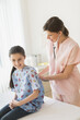© Tetra Images/Tetra Images - Doctor examining girl (8-9)