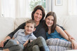 © Tetra Images/Tetra Images - Mother and kids(8-9, 10-11) sitting on sofa