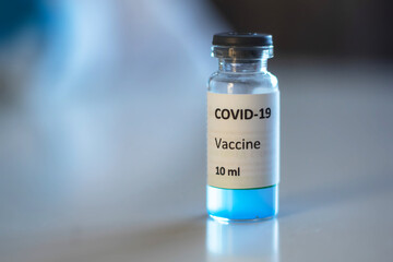 Concept of Covid 19 vaccine vaccinating, development and creation, doctor or scientist in laboratory holding a single dose of  2019-ncov vaccine, a syringe and ampule with SARS-CoV-2 vaccination