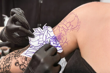 Professional artist making tattoo in salon