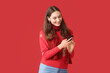 © Pixel-Shot - Beautiful young woman listening to Christmas music on color background