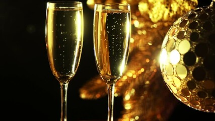 Wall Mural - Christmas Champagne. Two Flutes with Sparkling Wine over golden Holiday Blinking Background. Christmas and New Year Celebration. 