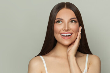 Happy surprised woman spa model with clear skin and long healthy straight hair. Skincare and facial treatment concept