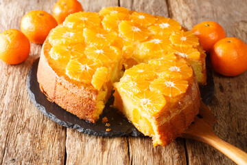 Wall Mural - Delicious cut tangerine pie close-up on a slate board on the table. horizontal