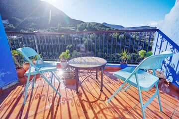 Table and chairs on the balcony terrace with nice view over the Chefchaouen, Morocco.