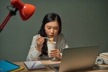 Asia Freelance Smart Business Women Eating Instant Noodles While Working On Laptop In Living Room At Home At Night