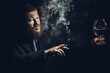 © idea_studio - Solid confident bearded man in suit with glass of whisky and cigar with fume
