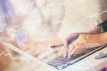 Double exposure of woman hands typing on computer and forex chart hologram drawing. Stock market invest concept.