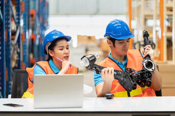 Product quality inspection team at storage warehouse. Asian male and female worker checking out spare parts in the automotive spare parts storage warehouse before shipment. Inspection quality control