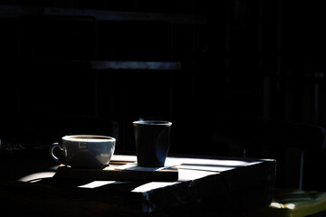 Fresh coffee in a white mug that is placed on the table in the morning