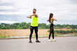 © Georgii - Young sporty couple working out together outdoor, fit pair performing fitness exercise with partner
