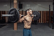 © splitov27 - Portrait of a young muscular bodybuilder with a barbell on his shoulders in a modern health club
