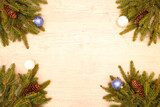 Fototapeta Nowy Jork -  Fir branches with cones lie on a wooden background decorated with Christmas cookies and Christmas balls.