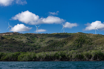 Panoramic view on the windmills on the mountain with cloudy sky and blue water of Atlantic Ocean, Punta Rucia, Dominican Republic 