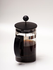 A cup of coffee and french press on a white isolated background