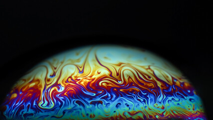 Wall Mural - macro picture of half soap bubble on black ground look like abstract psychedelic color planet in spa