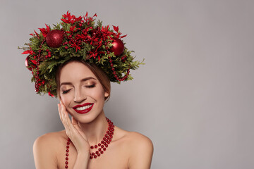 Wall Mural - Beautiful young woman wearing Christmas wreath on grey background. Space for text