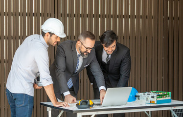 Business men and engineer are discussing or checking new project for solar energy on roof top. Clean energy for business development to avoid pollution