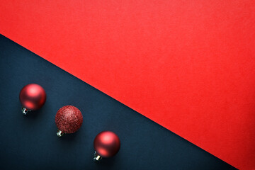 Composition of three Christmas balls on a black and red background.