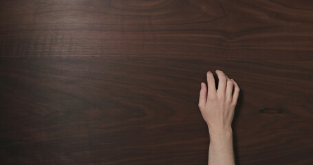 Wall Mural - Top view man hand finger tap on black walnut table with copy space