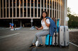 © Nomad_Soul - Woman sitting on suitcase, entrance to car parking