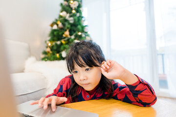 Wall Mural - Asian kids sibling sister brother video call in christmas holidays celebrate at home.Online video call zoom.Kids watching video with laptop.New normal.Covid-19 coronavirus.Social distancing.stay home.