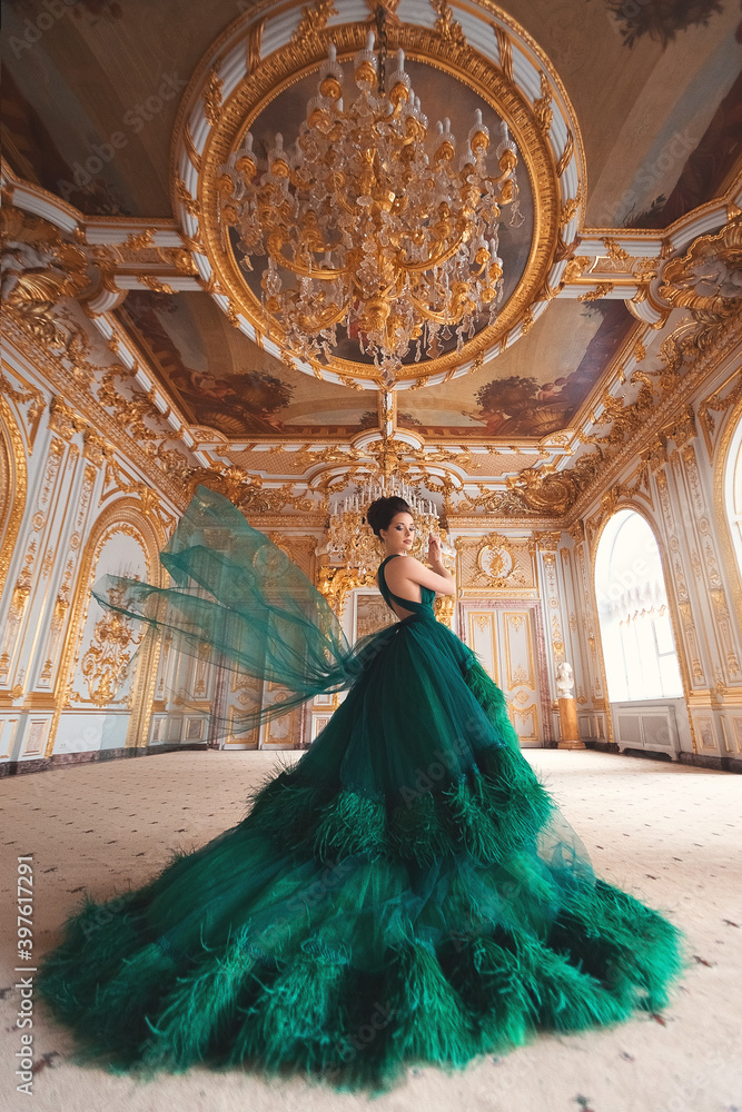 Portrait of a beautiful young girl in a Haute couture green dress standing  in a luxurious gold interior. Stock Photo | Adobe Stock