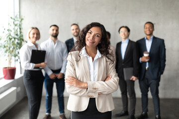 Wall Mural - Businesswoman Standing In Front Of Her Employees Posing In Office