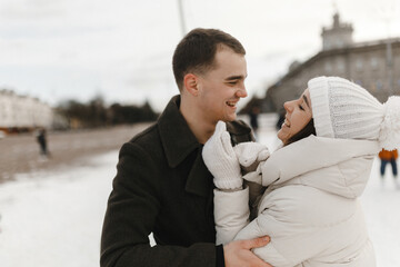 Wall Mural - Happy couple in love having fun in winter. Man hugs beautiful man. Love story. Winter activities