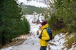 © Daniel Jędzura - Woman hiking in a yellow down jacket with a backpack on the trail in the mountains.