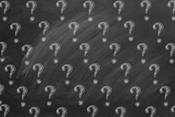 Question marks in chalk on a blackboard. Ask for help. FAQ concept. Asking questions.