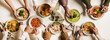 © sonyakamoz - People eating Autumn and Winter creamy vegan soups, fall and winter vegetarian food menu. Flat-lay of peoples hands with homemade soup in plates and bread slices over white table background, top view