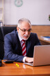 © Elnur - Old male employee sitting in the office