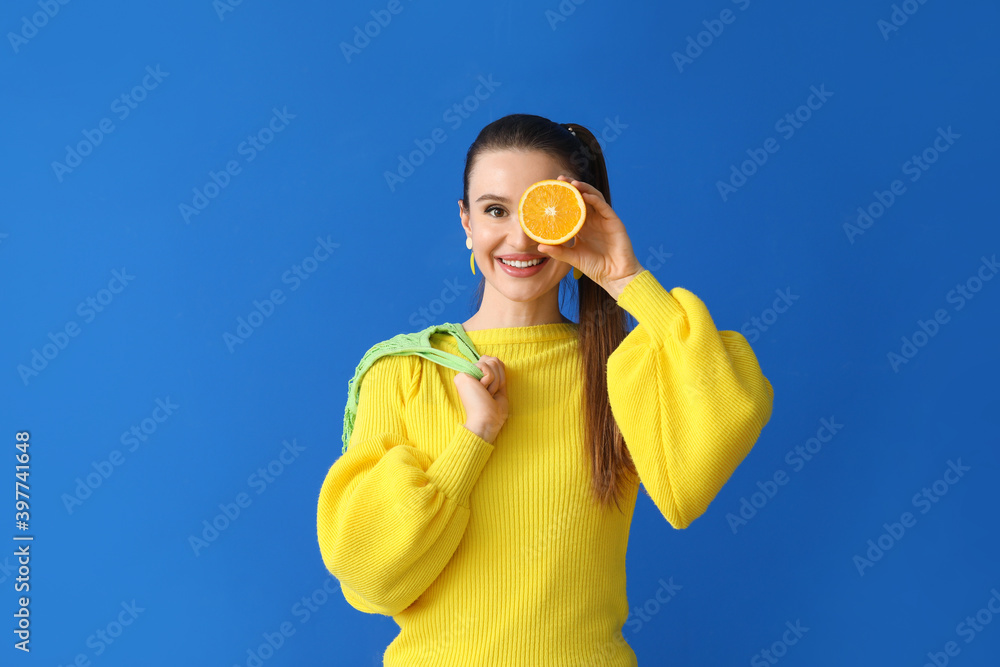 Beautiful young woman with oranges on color background