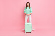 Full length body size view of pretty cheerful girlish girl traveler having fun with valise isolated on pink pastel color background