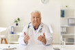 © Studio Romantic - Senior doctor sitting at desk, looking at camera and giving health advice to patient