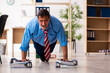 © Elnur - Young male employee doing sport exercises at workplace