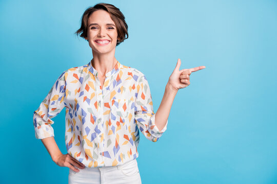 Photo of happy cheerful positive young woman point finger empty space isolated on pastel blue color background