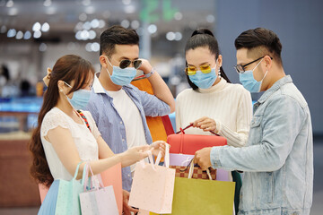 Poster - Group of friends in medical masks showing each other what they bought for Christmas